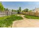 Fenced back yard has a concrete patio, gravel firepit area and view of a neighborhood playground at 6213 Selago Dr, Indianapolis, IN 46203