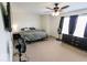 Neutral bedroom featuring a ceiling fan, windows, and carpet, offering a bright and versatile living space at 6213 Selago Dr, Indianapolis, IN 46203