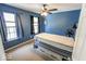 Blue bedroom featuring a ceiling fan, windows, and neutral carpet, with an inviting and cozy ambiance at 6213 Selago Dr, Indianapolis, IN 46203