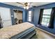 Blue bedroom featuring a ceiling fan, windows, and neutral carpet, offering a serene and inviting space at 6213 Selago Dr, Indianapolis, IN 46203
