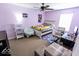 Light purple bedroom featuring a ceiling fan, windows, and neutral carpet, providing a comfortable and functional space at 6213 Selago Dr, Indianapolis, IN 46203