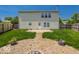 View of the back of the two-story house with patio, firepit, fenced yard and lush trees at 6213 Selago Dr, Indianapolis, IN 46203
