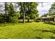 Expansive backyard with mature trees and lush lawn, showcasing the home's serene outdoor space at 6220 Spring Mill Rd, Indianapolis, IN 46260