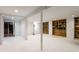 Spacious basement with white painted walls, wooden shelves, and ample open area at 6220 Spring Mill Rd, Indianapolis, IN 46260