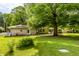 Inviting front yard with mature trees, green lawn, and charming home exterior with white picket fence at 6220 Spring Mill Rd, Indianapolis, IN 46260