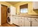 Practical laundry room featuring a stacked washer/dryer, sink, and ample storage space at 6220 Spring Mill Rd, Indianapolis, IN 46260