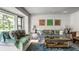 Bright living room featuring stylish sofas, art, and a large window with a view of the lush greenery outside at 6220 Spring Mill Rd, Indianapolis, IN 46260