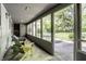 Enclosed sunroom featuring natural light, seating, and views of the lush backyard at 6220 Spring Mill Rd, Indianapolis, IN 46260