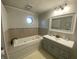 Bathroom featuring built-in tub with tiled surround, and light blue vanity at 71 W County Road 500 S, Clayton, IN 46118