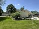 Charming home featuring well-manicured lawn, lush landscaping, and a welcoming carport at 71 W County Road 500 S, Clayton, IN 46118