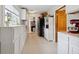 Bright kitchen area with white cabinets and shelving, featuring a stainless steel fridge and adjacent doorway at 71 W County Road 500 S, Clayton, IN 46118