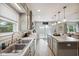 Functional kitchen with stainless steel sink, countertops, gray cabinets, and a center island with barstool seating at 71 W County Road 500 S, Clayton, IN 46118