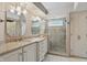 Bathroom featuring double vanity sinks, framed mirrors, tiled walk-in shower and enclosed toilet at 7329 Pymbroke Dr, Fishers, IN 46038