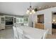 Bright dining area with white table, chandelier, built-in cabinet, and sliding glass doors to the outdoor deck at 7329 Pymbroke Dr, Fishers, IN 46038