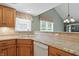 Kitchen with granite countertops, wood cabinets, modern appliances, and a view to the dining area at 7329 Pymbroke Dr, Fishers, IN 46038