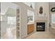 Bright and airy living room with fireplace and view of adjacent breakfast nook and kitchen at 7329 Pymbroke Dr, Fishers, IN 46038