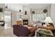 Bright living room with fireplace, sofas, and expansive windows, showcasing an open-concept design at 7329 Pymbroke Dr, Fishers, IN 46038