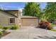 Tan home showcasing a garage, well-kept lawn, and mature landscaping at 740 Carya Sq, Columbus, IN 47201