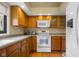 This kitchen has a hardwood floor, wood cabinets and modern white appliances at 740 Carya Sq, Columbus, IN 47201