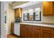 Kitchen with wood cabinets, a white dishwasher, and a window with a garden view at 740 Carya Sq, Columbus, IN 47201