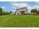 A spacious backyard with a grill, patio, green grass, and partial wooden fence at 7452 Lace Bark Ct, Avon, IN 46123