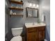 Half bathroom showing floating shelves, framed mirror, white countertop and cabinet sink at 7452 Lace Bark Ct, Avon, IN 46123