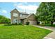 Charming brick home with attached garage, green shutters, and a lush, well-maintained lawn at 7452 Lace Bark Ct, Avon, IN 46123