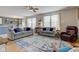 Bright living room featuring hardwood floors, a ceiling fan, and large windows at 7452 Lace Bark Ct, Avon, IN 46123