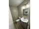 Half bathroom features a single sink vanity, a large mirror, and a toilet at 7514 Ruskin Pl, Indianapolis, IN 46226
