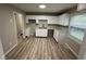 Bright kitchen with white cabinets, stainless steel sink, and durable vinyl flooring at 7514 Ruskin Pl, Indianapolis, IN 46226