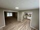 View of the living space showing vinyl flooring and access to a kitchen and carpeted living room at 7514 Ruskin Pl, Indianapolis, IN 46226