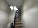 Carpeted staircase with dark railings and a unique chandelier is a perfect transition between floors at 7514 Ruskin Pl, Indianapolis, IN 46226