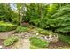 Picturesque backyard with stone pathways, lush landscaping, and a tranquil pond, creating a serene outdoor space at 7624 William Penn Pl, Indianapolis, IN 46256