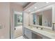 Bright bathroom with a vanity, large mirror, and view to bedroom and exterior at 7624 William Penn Pl, Indianapolis, IN 46256