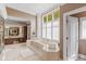 Elegant bathroom featuring a soaking tub, dual vanity, and natural light at 7624 William Penn Pl, Indianapolis, IN 46256