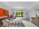 Bright bedroom featuring a large window overlooking a serene outdoor space and a decorative Bengals flag at 7624 William Penn Pl, Indianapolis, IN 46256