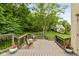 Inviting deck with rocking chairs and lush greenery providing a private backyard retreat and a home in the background at 7624 William Penn Pl, Indianapolis, IN 46256