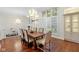 Bright dining room featuring wood floors, elegant lighting, and large window with shutters at 7624 William Penn Pl, Indianapolis, IN 46256