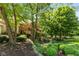 Beautifully landscaped front yard with mature trees and shrubs leading to a well-maintained home exterior at 7624 William Penn Pl, Indianapolis, IN 46256