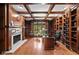 Elegant home office features rich wood paneling, built-in shelves, and fireplace at 7624 William Penn Pl, Indianapolis, IN 46256