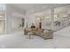 Bright, open-concept living room featuring a large sectional sofa and elegant staircase at 7624 William Penn Pl, Indianapolis, IN 46256