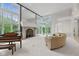 Bright living room featuring a grand fireplace, piano, and large windows at 7624 William Penn Pl, Indianapolis, IN 46256