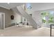 Bright living room featuring a staircase and view to the exterior of the property at 7624 William Penn Pl, Indianapolis, IN 46256