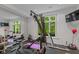 Well-lit workout room with exercise equipment, mirrors, and view to the exterior at 7624 William Penn Pl, Indianapolis, IN 46256