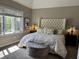 Bedroom featuring a upholstered headboard, neutral color palette, and bright window at 7661 Carriage House Way, Zionsville, IN 46077