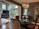 Dining room with large windows, hardwood floors, chandelier, and a clear view to the living room at 7661 Carriage House Way, Zionsville, IN 46077