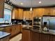 Kitchen with central island including cooktop, granite countertops, and stainless appliances at 7661 Carriage House Way, Zionsville, IN 46077