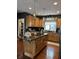 Kitchen with central island including cooktop, granite countertops, and custom cabinetry at 7661 Carriage House Way, Zionsville, IN 46077