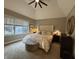 Comfortable main bedroom with neutral tones, a plush bed, and a sitting area near the window at 7661 Carriage House Way, Zionsville, IN 46077