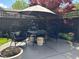 Outdoor patio featuring a table and chairs set, an umbrella, fire pit, and decorative landscaping offering a relaxing atmosphere at 7661 Carriage House Way, Zionsville, IN 46077